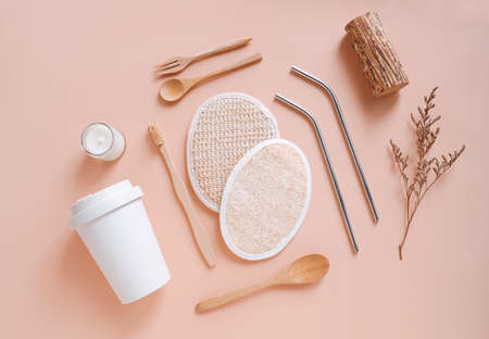 Flat lay of sustainable products, bamboo toothbrush, stainless straw with travel mug and organic scrub pad on autumn color background, eco friendly and zero waste conceptの写真素材