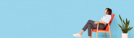 A tired businesswoman relaxing on chair with calm expression in bright office spaceの素材