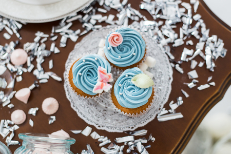 Three tasty blue cupcakes with decorations marshmallow on wooden tableの写真素材