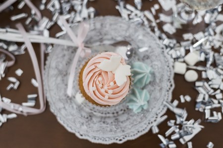Tasty pink cupcake with decorations marshmallow on wooden tableの写真素材