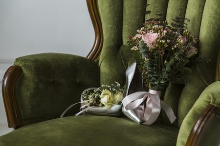 Shoes with a wedding bouquet of flowers on a chairの写真素材