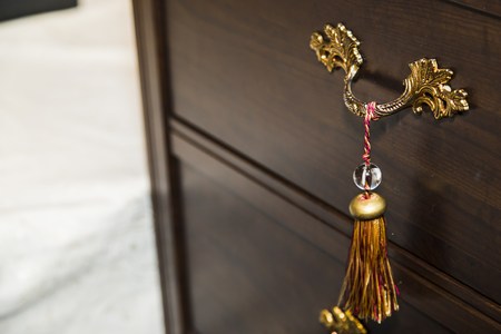 Decor tassel in nightstand, dark wood and gold