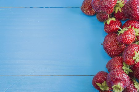 Fresh strawberries on blue wooden background, copyspaseの写真素材