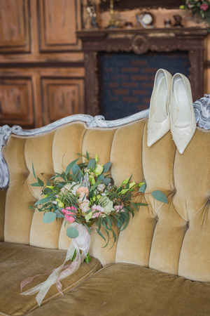 bridal bouquet with shoes, shot in interior on a vintage couchの写真素材