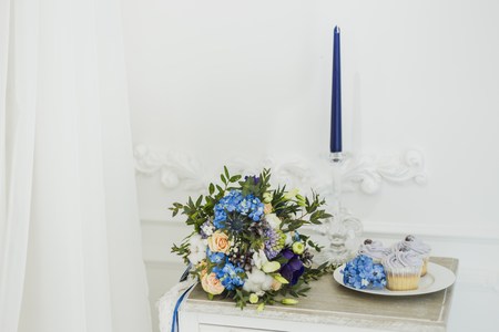 Wedding decorations with bride's bouquet, candle and cupcakes. blue and serenityの写真素材