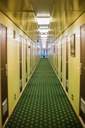 Long corridor of cruise ship, yellow and brown walls and doorsの写真素材