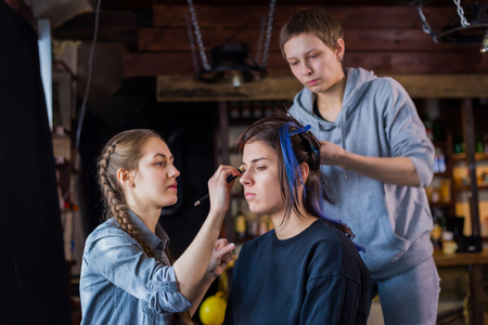 Professional make-up artist and hairdresser working with woman client. Beauty, haircare and make up conceptの写真素材