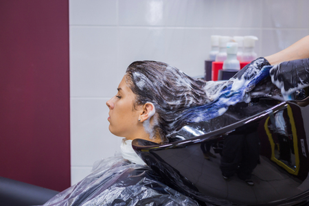 Professional hairdresser, stylist washing hair of woman client at salon, studio. Beauty and fashion conceptの写真素材