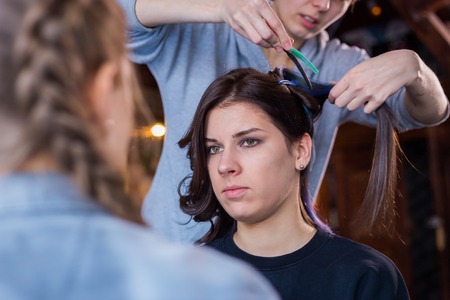 Professional make-up artist and hairdresser working with woman client. Beauty, haircare and make up conceptの写真素材
