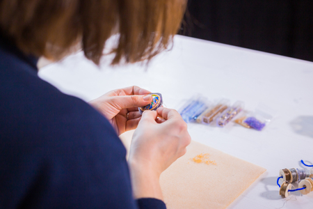 Professional jewelry designer making handmade brooch with beads in studio, workshop. Fashion, creativity and handmade conceptの写真素材