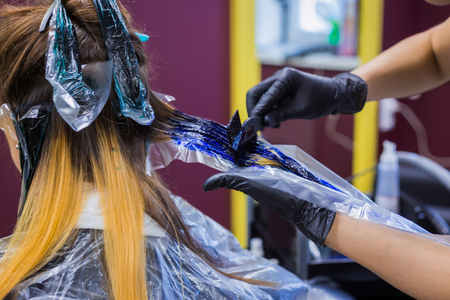 Professional hairdresser, stylist coloring hair of woman client at salon, studio. Beauty and fashion conceptの写真素材