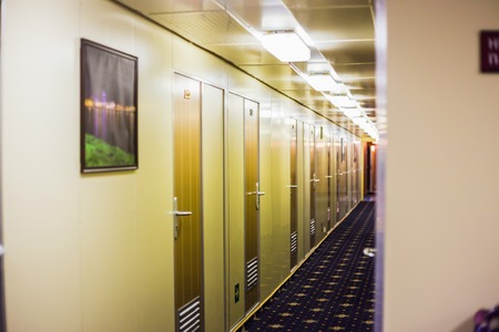 Long corridor of cruise ship, yellow and brown walls and doorsの写真素材