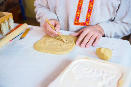 Professional male potter making clay stamp picture. Handwork, crafting and traditional arts concept