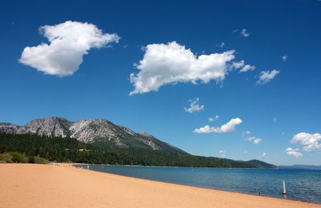 Lake Tahoe beach on a sunny day wtih blue skies and silky cloudsの写真素材