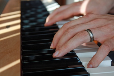 Closeup of fingers playing the piano