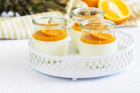 Vanilla panna cotta with exotic fruits sauce over dark wooden table. Selective focusの写真素材