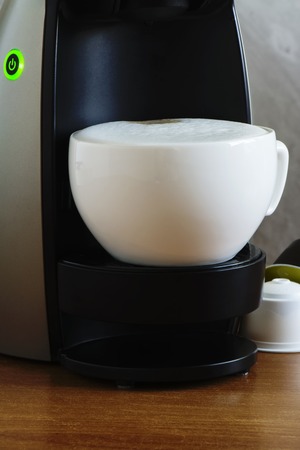 Coffee machine and cup of cappuccino, closeupの写真素材