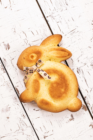 Easter bunny cake with a bow over white wooden tableの写真素材