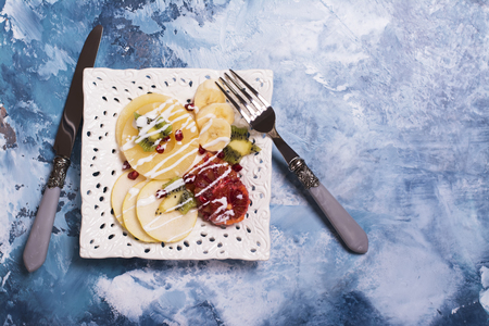 Fruit salad with pear, pineapple, pomegranate and banana, top viewの写真素材