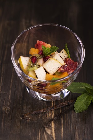 Fruit salad in glass bowls over dark wooden table. Selective focusの写真素材