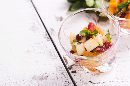 Fruit salad in glass bowls over white wooden table. Selective focusの写真素材