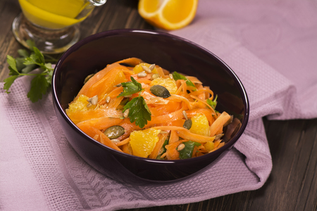 Salad with fresh carrot, orange slices, pumpkin and  sunflower seeds. Selective focusの写真素材