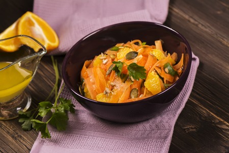 Salad with fresh carrot, orange slices, pumpkin and  sunflower seeds. Selective focusの写真素材