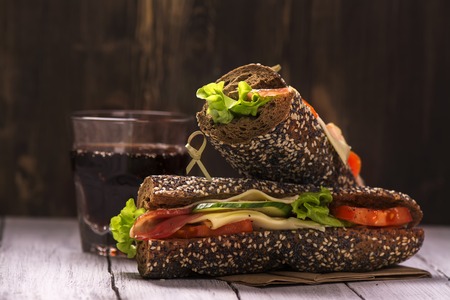 Rye bread sandwiches and glass of cola over wooden background. Selective focusの写真素材