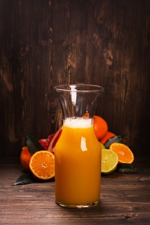 Bottle of fresh homemade citrus juice over wooden table. Selective focusの写真素材