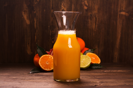 Bottle of fresh homemade citrus juice over wooden table. Selective focusの写真素材