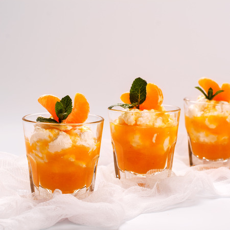 Layered panna cotta with whipped cream and tangerine sauce. Selective focusの写真素材