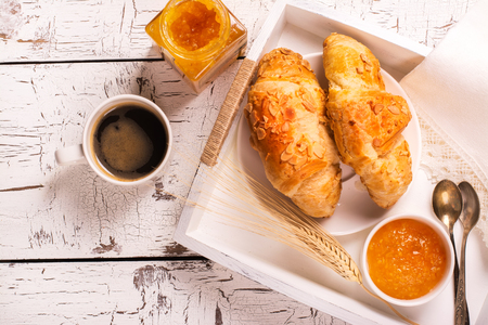 Traditional french breakfast. Crunch croissants and black coffee in a white wooden trayの写真素材