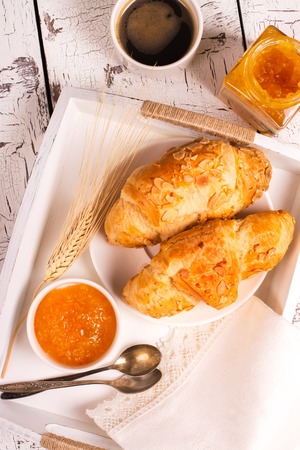 Traditional french breakfast. Crunch croissants and black coffee in a white wooden trayの写真素材
