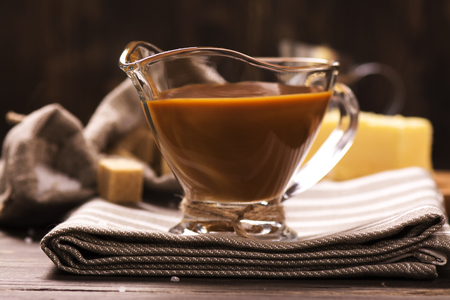 Caramel sauce and ingredients over grunge wooden background. Rustic style. Selective focusの写真素材