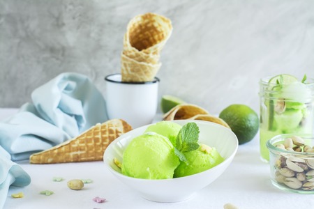 Homemade pistachio sorbet with lime, mint leaves, nuts and waffle cones. Selective focusの写真素材