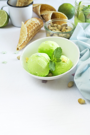 Homemade pistachio sorbet with lime, mint leaves, nuts and waffle cones. Selective focusの写真素材