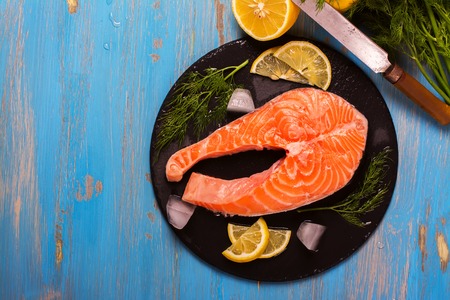 Raw salmon steaks and ingredients on slate background. Selective focus. Top viewの写真素材