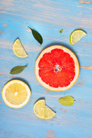 Citrus fruits slices over blue wooden table. Top view. Selective focusの写真素材