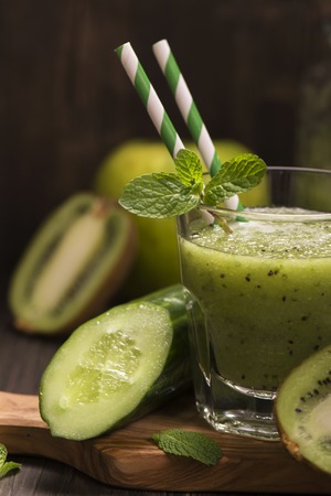 Glass of green refreshing smoothie with kiwi, cucumber and apple. Toned image. Selective focusの写真素材