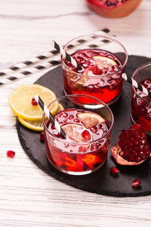 Pomegranate cocktail with lemon slices over wooden backgroundの写真素材