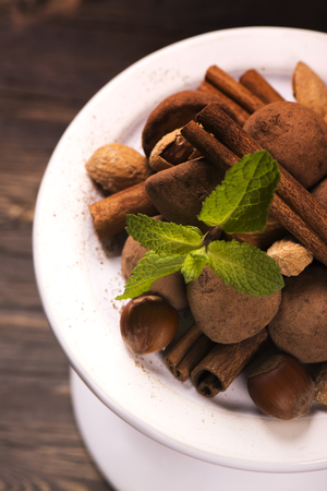 Chocolate truffle candies and assortment of nuts over grunge wooden backgroundの写真素材