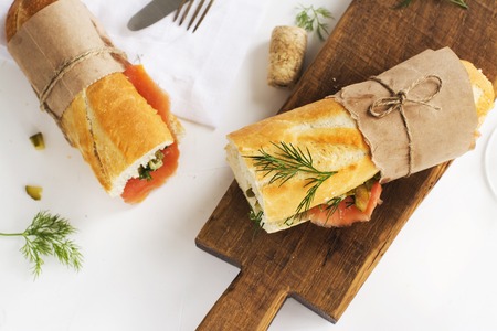 Sandwiches with smoked salmon, potato, pickled cucumbers and dill over white background. Selective focusの写真素材