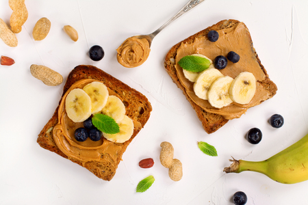 Peanut butter sandwiches with bananas and blueberry. Top view. Space for textの写真素材