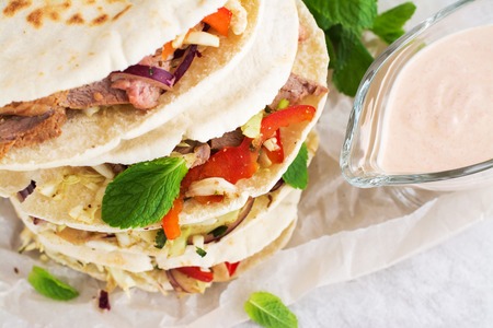 Meat pita bread with yogurt sauce and mint leaves. Selective focus