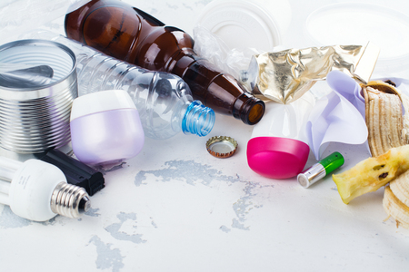 Pile of unsorted waste on white stone background. Copy space. Ecological or recycling conceptの写真素材