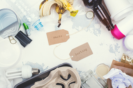 Pile of unsorted waste on white stone background. Copy space. Ecological or recycling conceptの写真素材