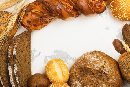 Assortment of fresh baked bread and buns on kitchen table. Space for text. Top viewの写真素材