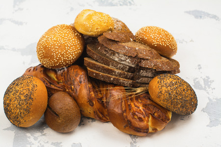 Assortment of fresh baked bread and buns on kitchen table. Space for text. Top viewの写真素材