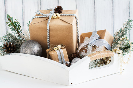 Pile of christmas gift box with decorations on a wooden tray. Selective focus.の写真素材