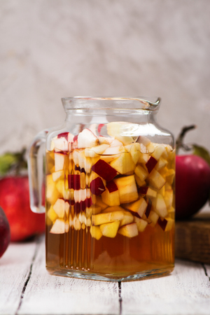 Apple cider sangria in a glass jar on wooden table. Vintage style. Selective focusの写真素材